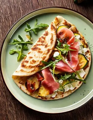 Ricetta Piadina conprosciutto cotto, crescenza, zucchine grigliate e rucola di eltamain