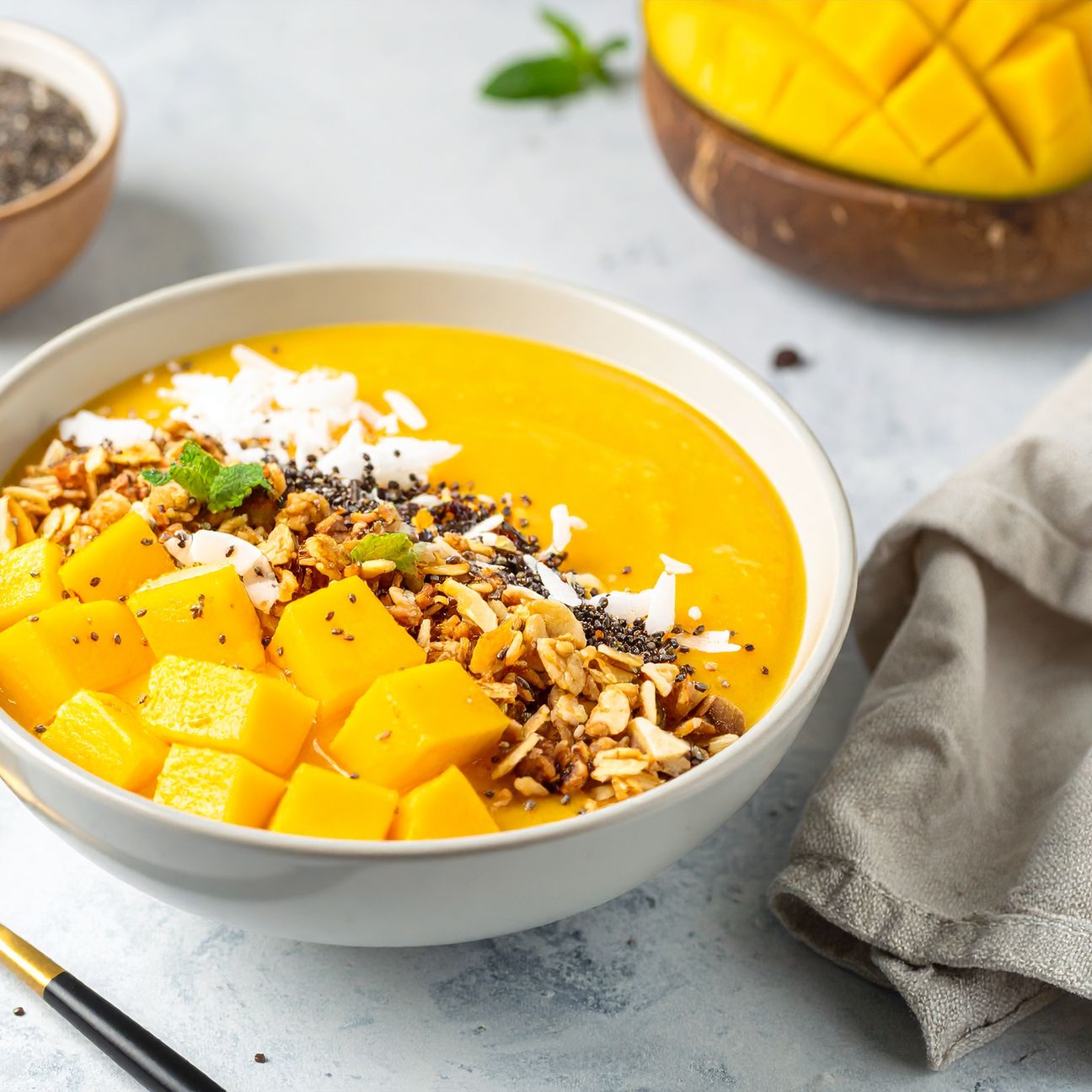 Smoothie bowl al mango e cocco con granola e semi di chia