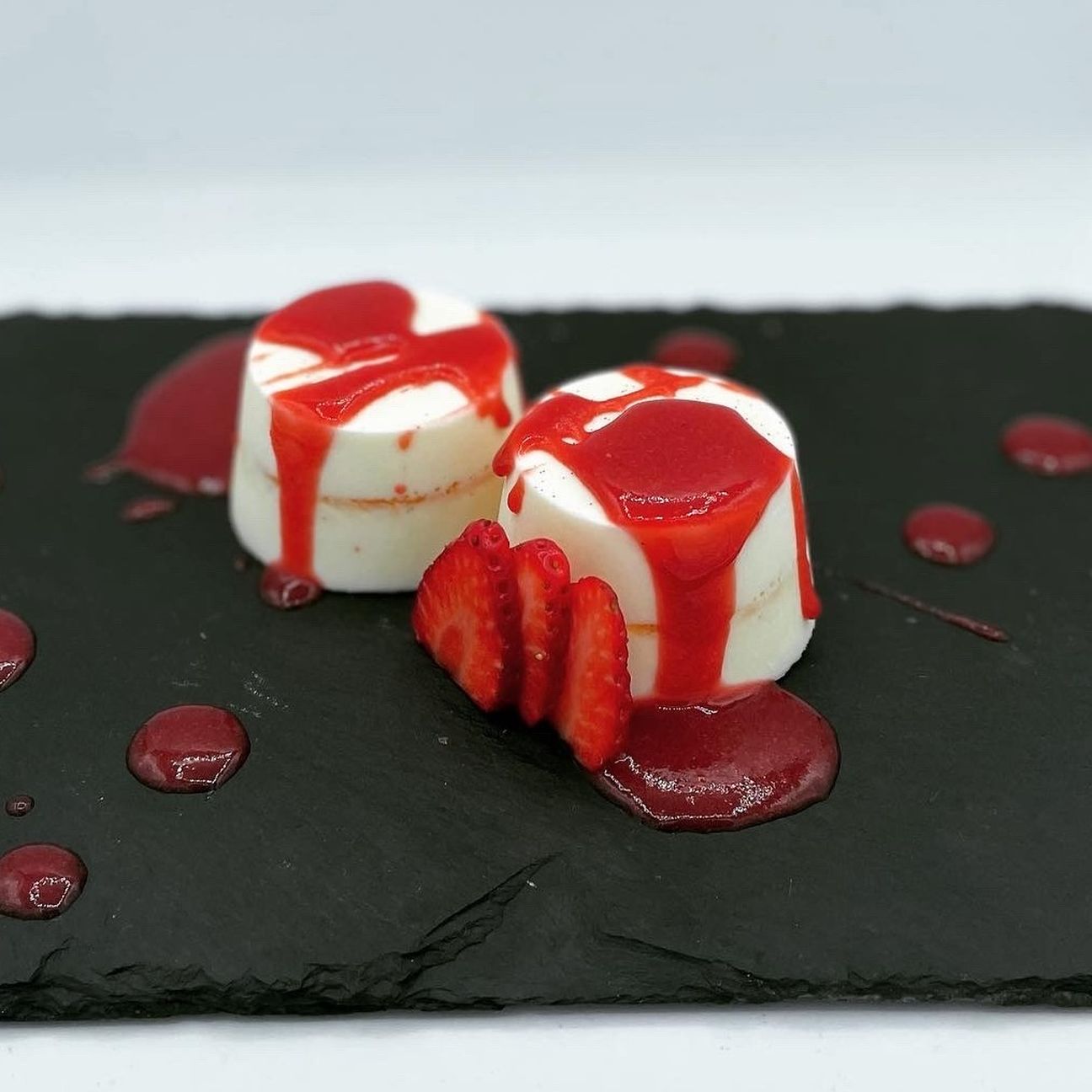 Panna cotta con strato di passion fruit e salsa di fragole