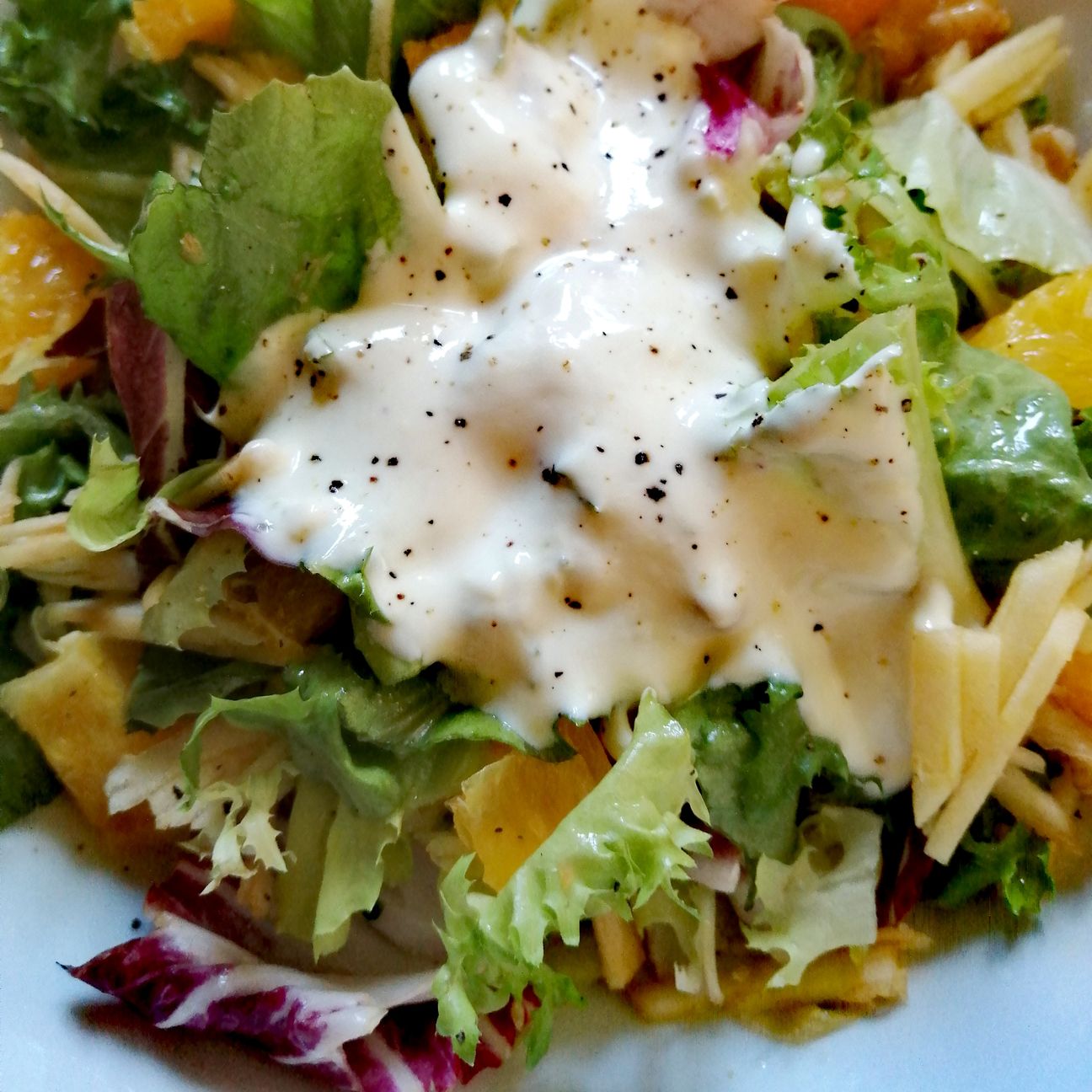 Insalata mista con mela, arancia, succo di limone e noci