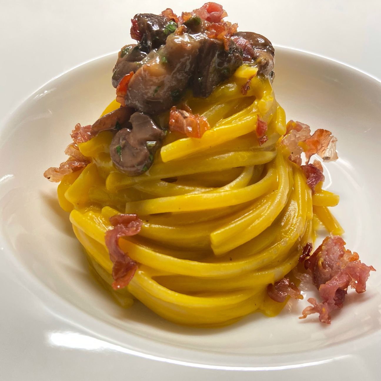 Linguine con crema di zucca, porcini e crudo di Parma