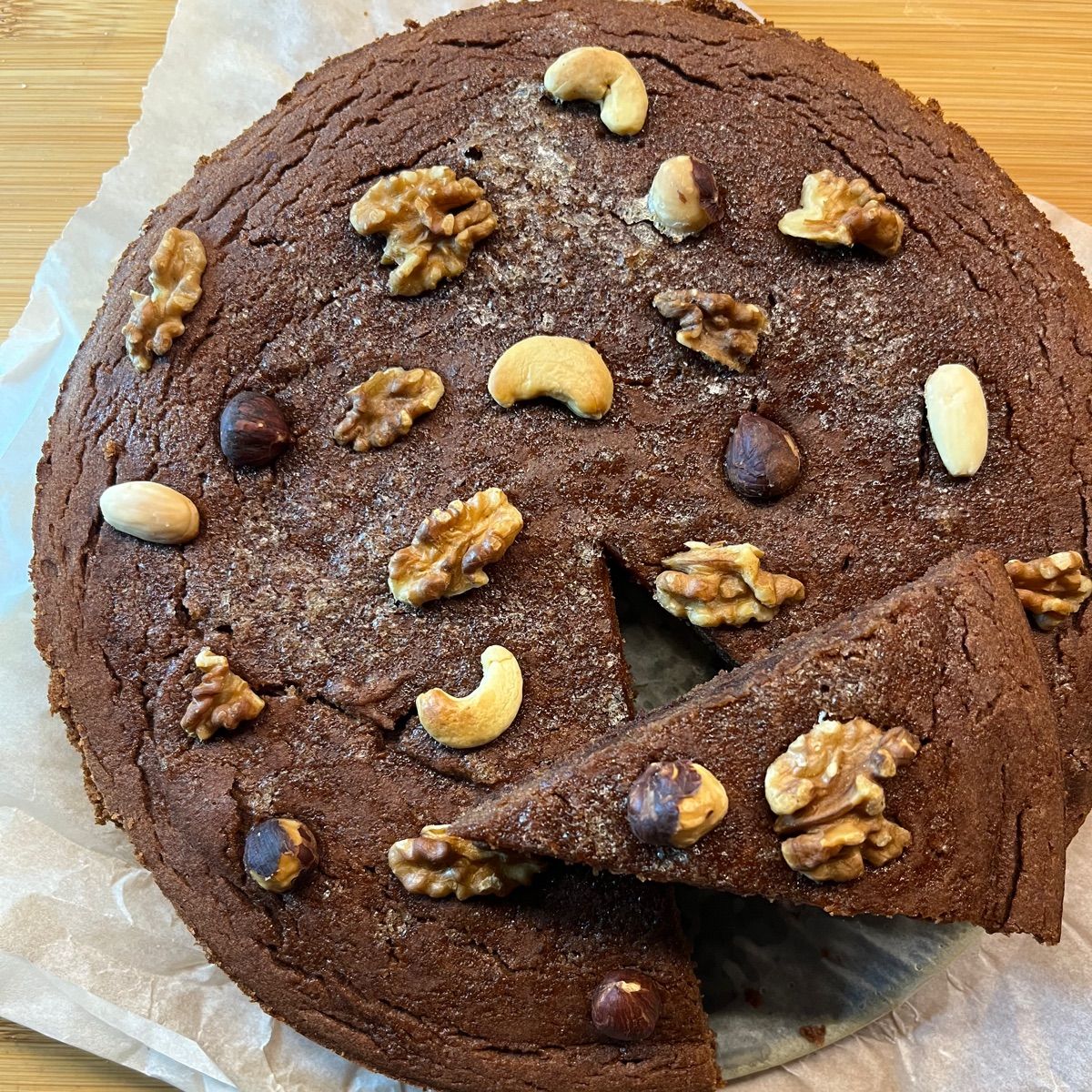 Torta di cachi e cacao amaro senza glutine con frutta secca, cioccolato fondente e ripieno di gelato alla vaniglia bourbon