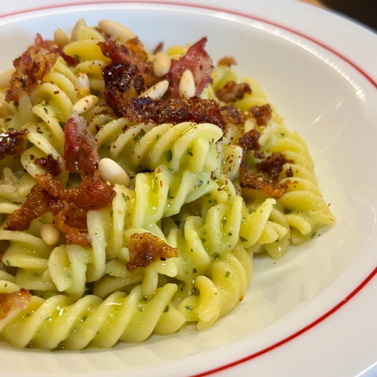 Fusilli con crema di zucchine, guanciale, pinoli, fiocchi di peperoncino