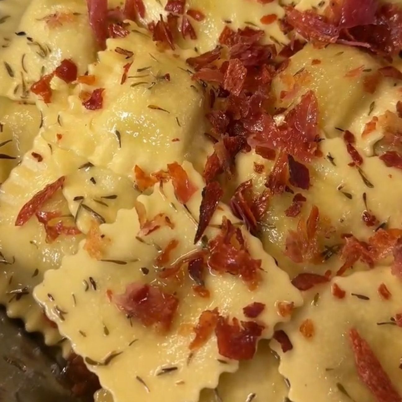 Ravioli di carciofi con burro al timo, speck croccante e nocciole