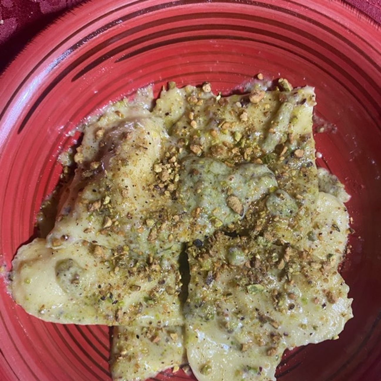 Ravioli al pesto di pistacchio ripieni di ricotta mortadella e granella