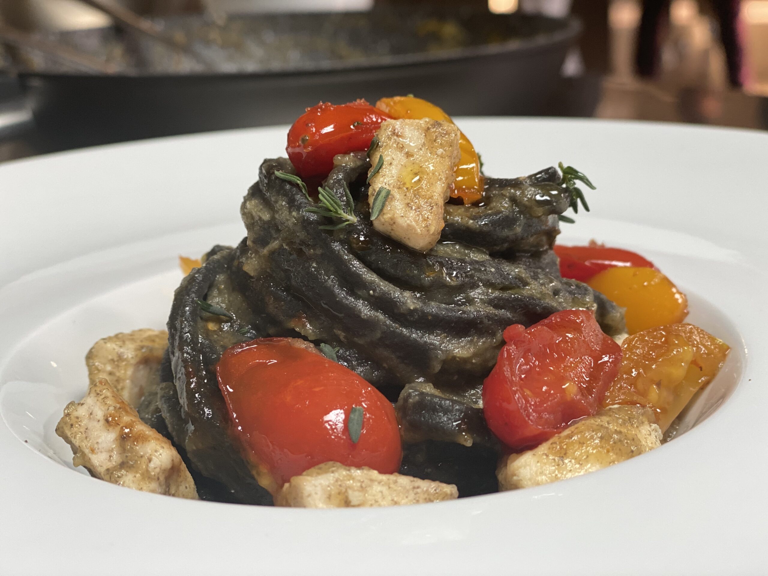 Penne al nero di seppia con calamari e pomodorini