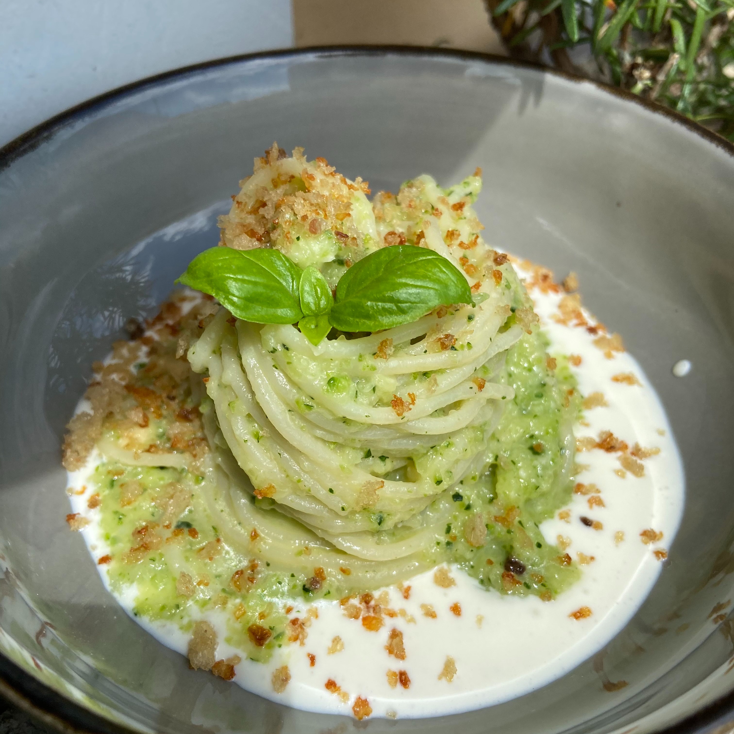 Spaghetti con pesto di zucchine, crema di robiola, crumble di pane e alici