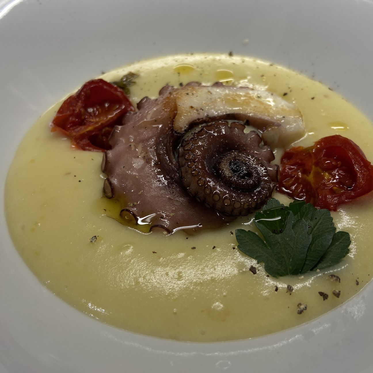 Polpo con crema di patate al cartoccio e pomodori arrostiti