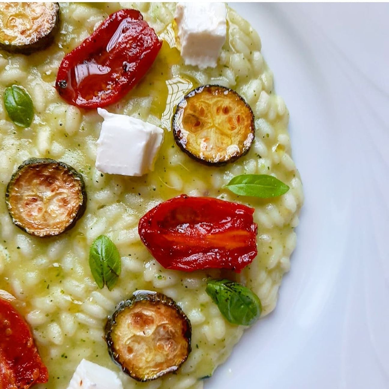Risotto in crema di zucchine e patata rossa, caprino, pomodori confit e basilico