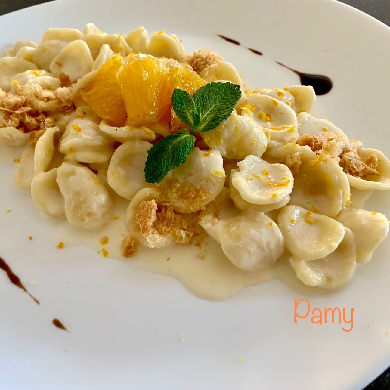 Orecchiette crema di ricotta aromatizzata agli agrumi, arancia caramellata, crumble di frisella, gocce di vincotto
