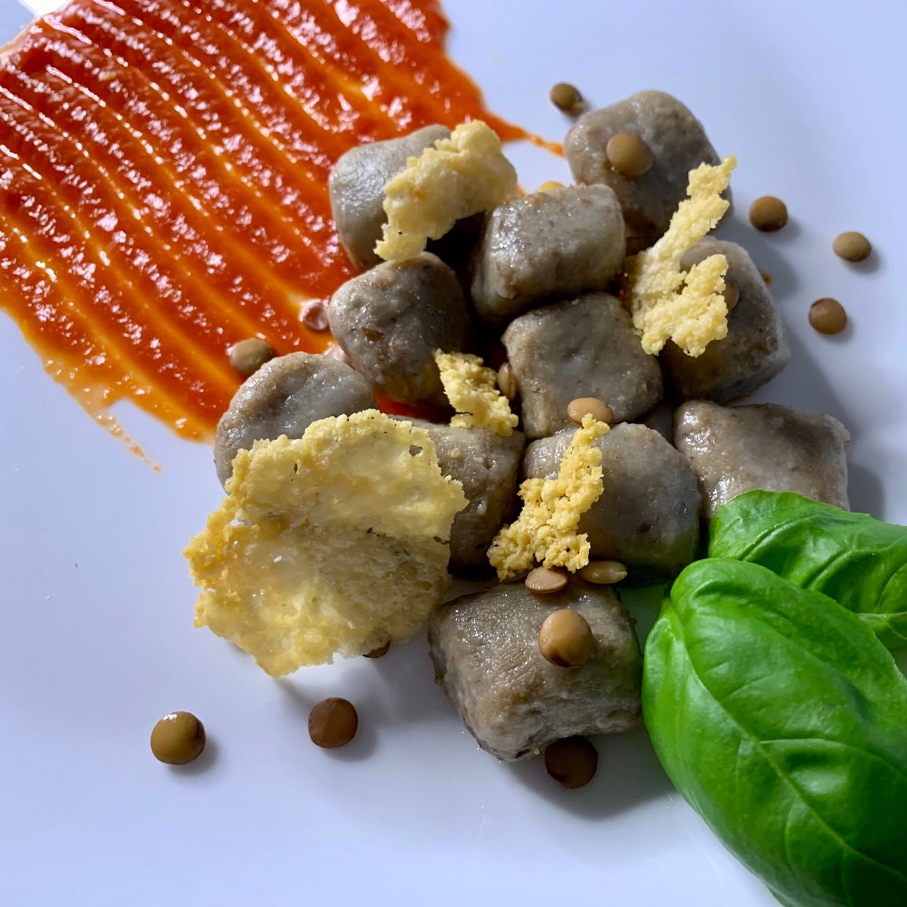 Gnocchi di lenticchie, salsa al pomodoro, cialdine croccanti di parmigiano