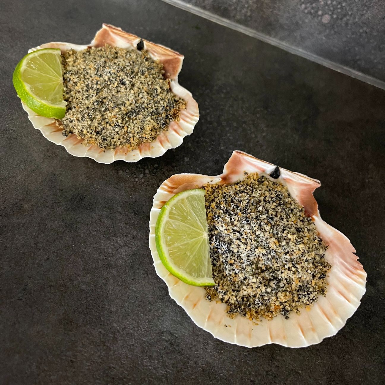 Capesante gratinate al nero di seppia e lime