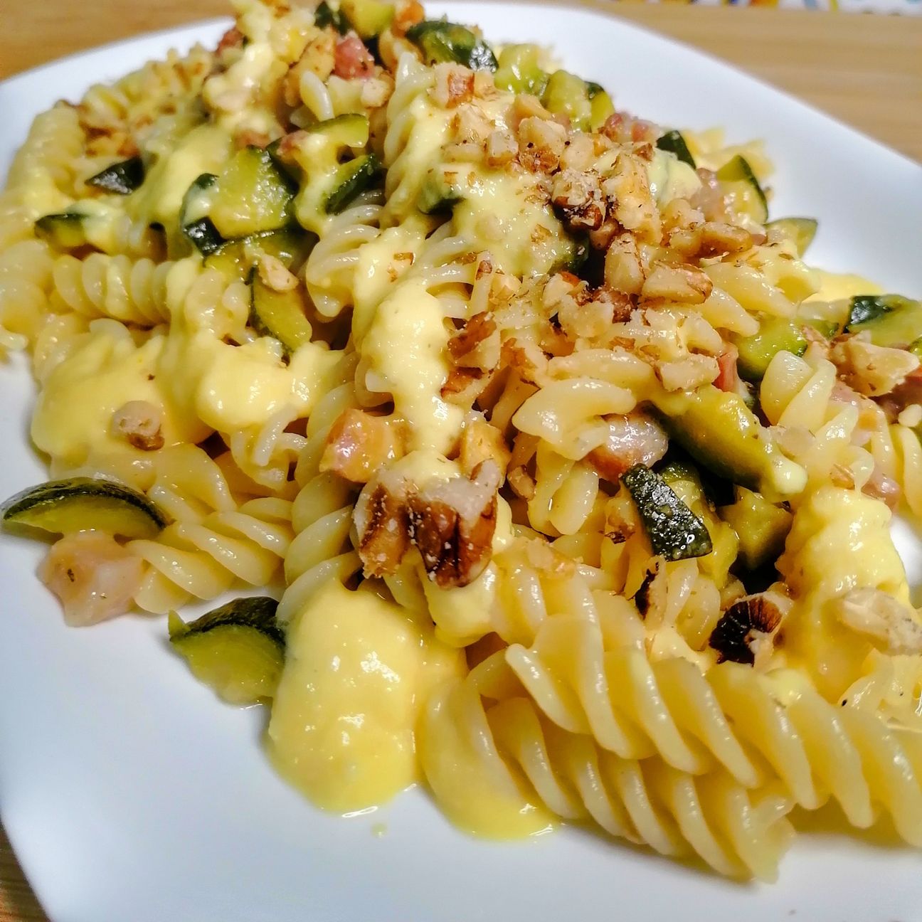 Fusilli con pancetta, zucchina e crema di parmigiano allo zafferano, più noci