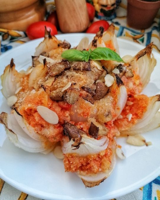 Cipolla di Giarratana ripiena di pesto alla Trapanese, melanzane fritte e muddica.