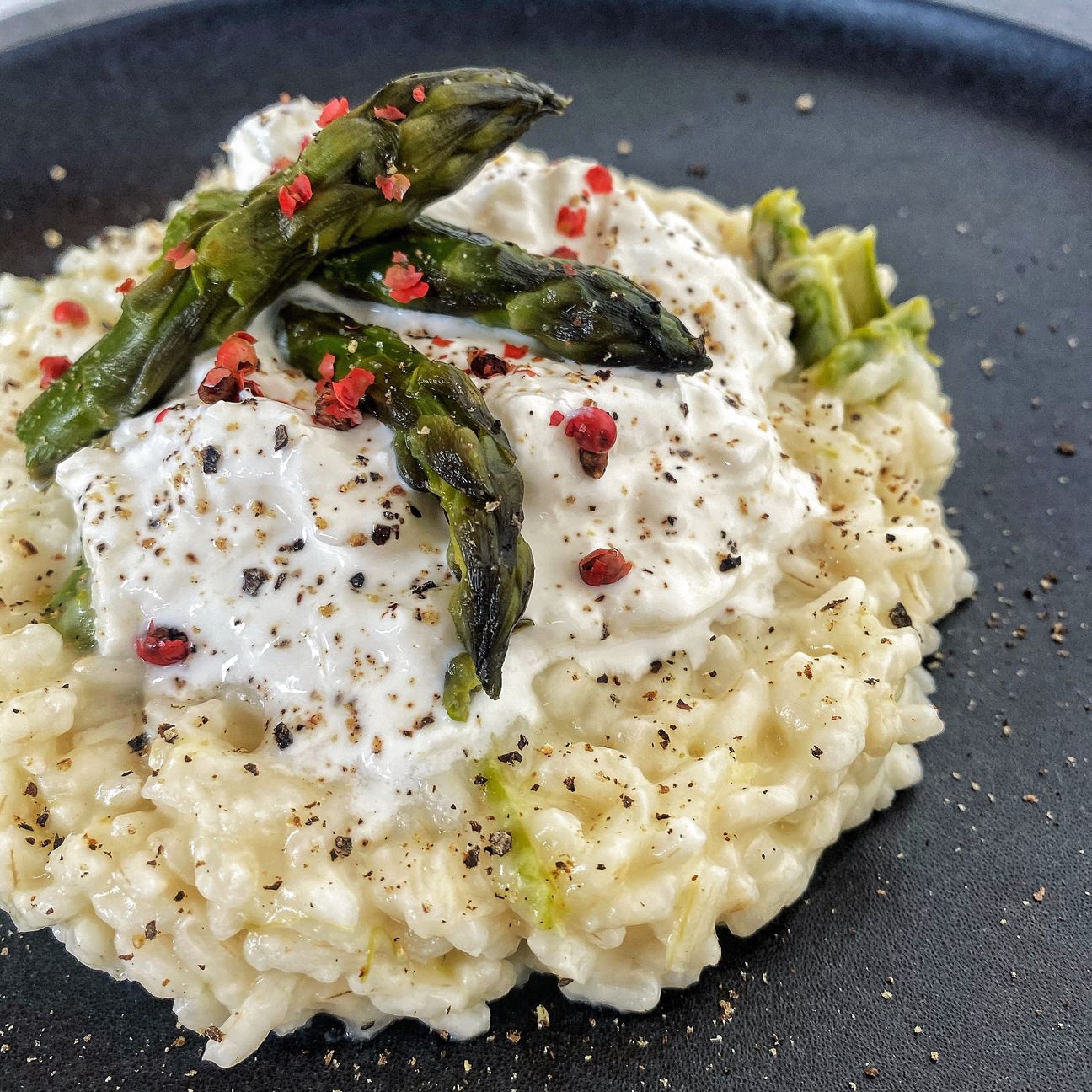 Risotto agli asparagi con taleggio, burrata, asparagi saltati e bacche rosa