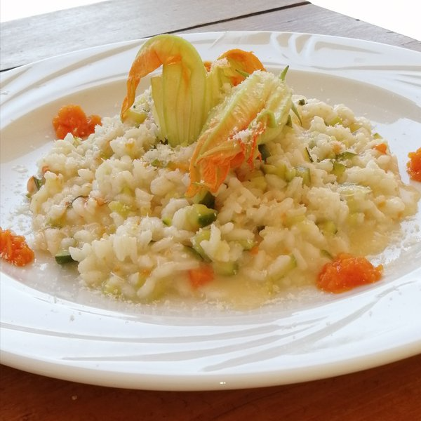 Risotto leggero di zucchine fiori di zucca mantecato con crema di carote.