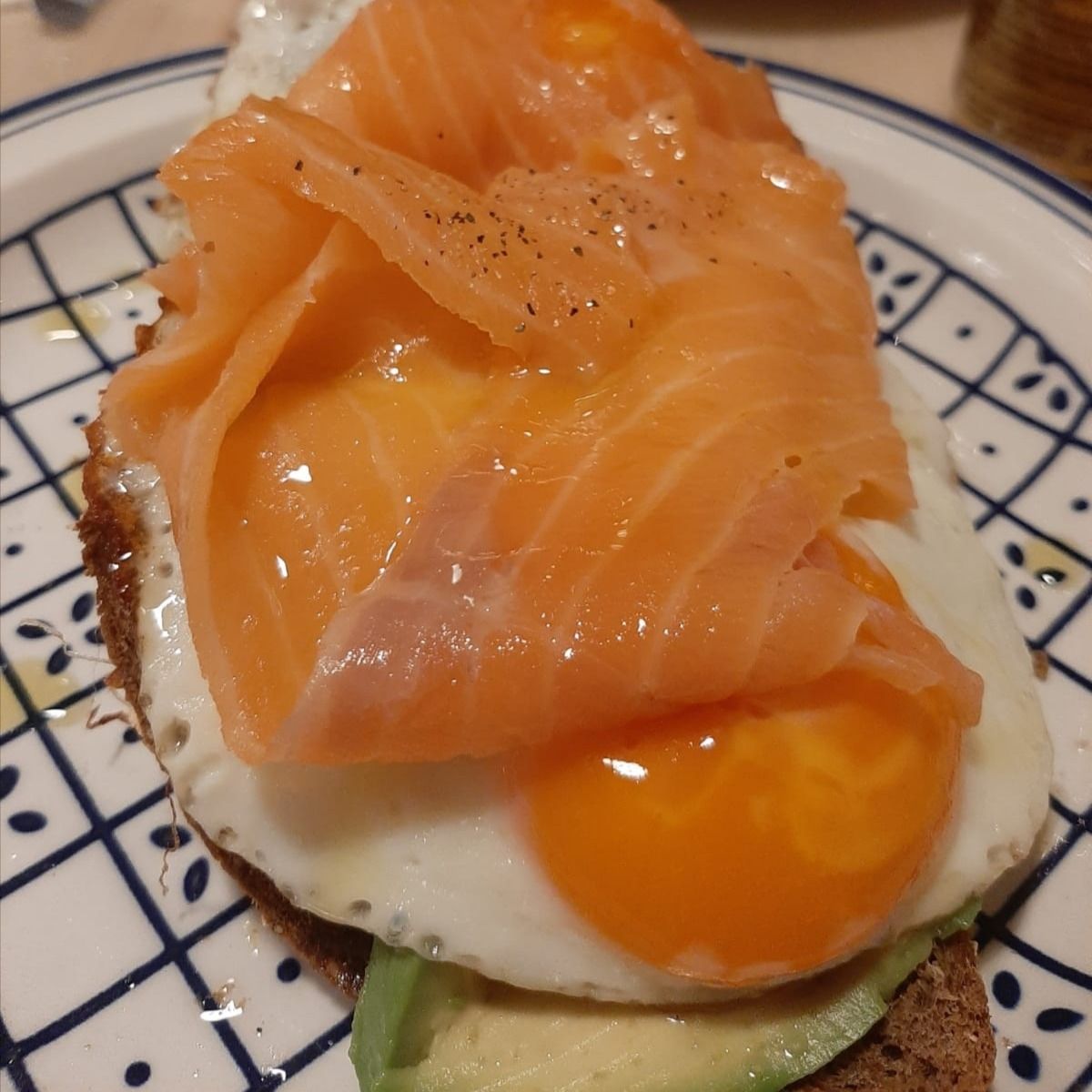 Occhio di bue su pane di segale tostato con avocado è salmone affumicato