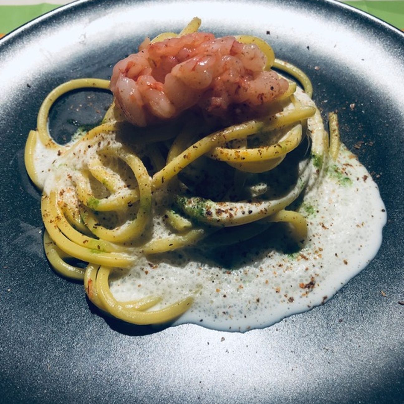Spaghetti cremosi con spuma di burrata, polvere di cime di rapa, crudo e polvere di gambero rosso