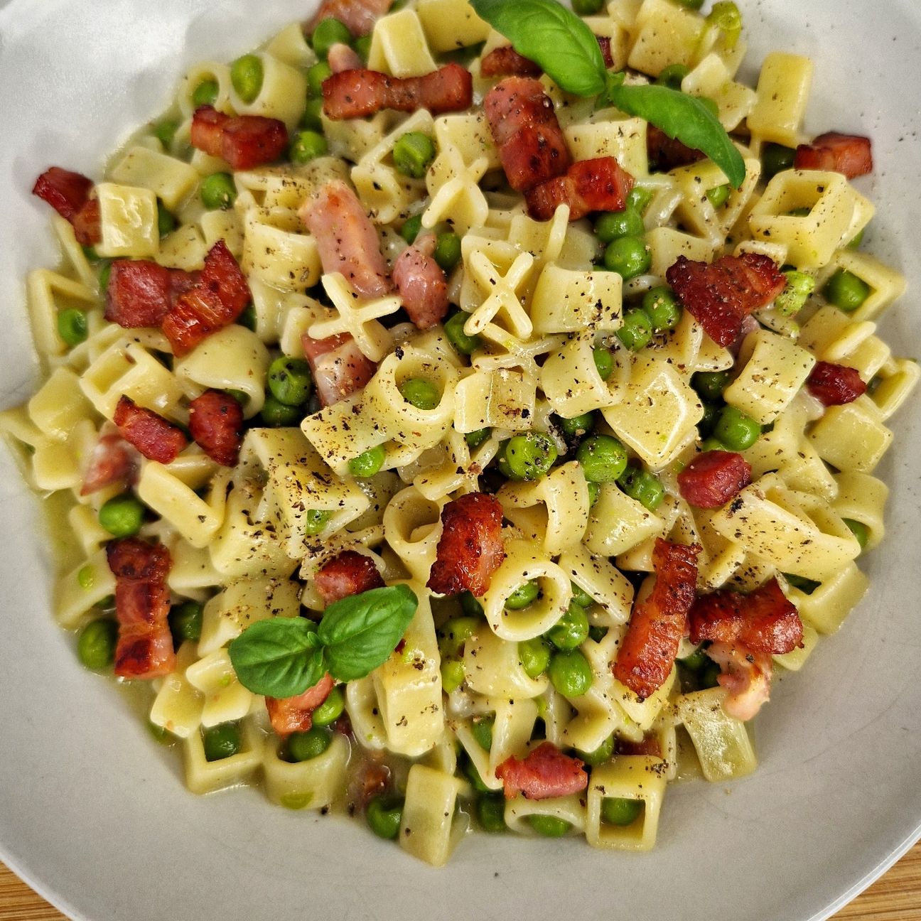 Play your pasta risottata con piselli, pancetta, parmigiano e pepe