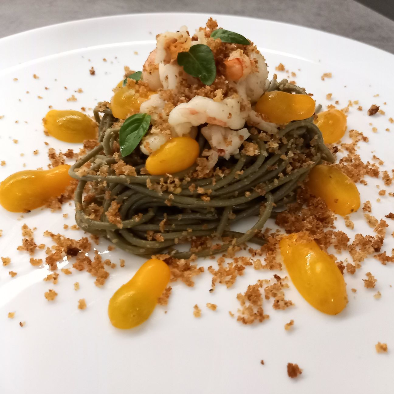 Spaghetti con pomodori datterini, gamberi e mollica saltata