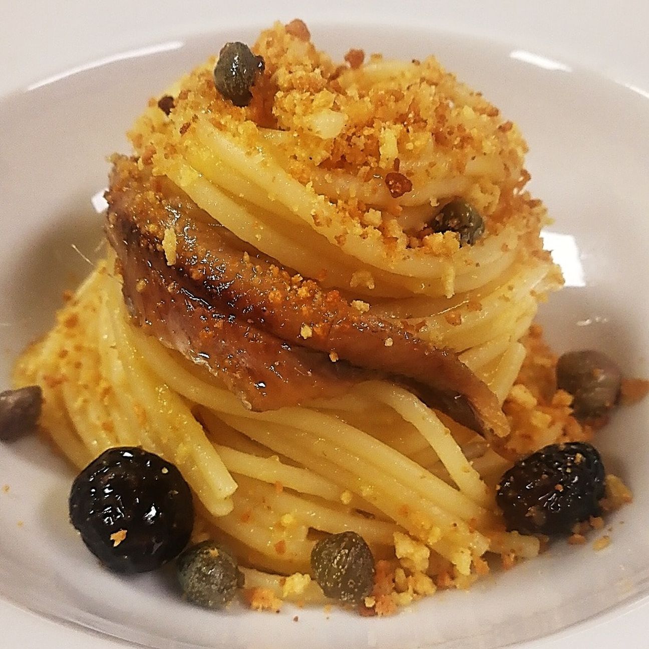 Spaghetti con datterino giallo di Sicilia, olive, capperi, acciughe e pangrattato