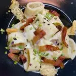 Ricetta Calamarata con crema di parmigiano, guanciale, granella di pistacchio e cialdine di parmigiano