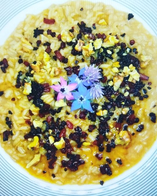 Risotto con aglio fermentato al miele e speck caramellato