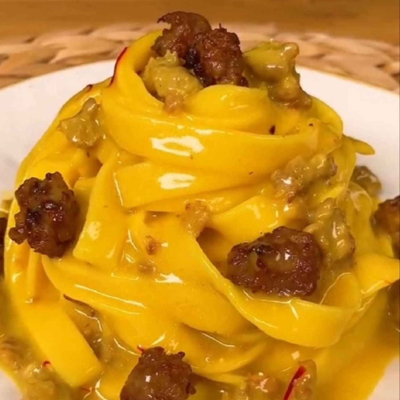 Pasta con crema di parmiggiano allo zafferano e salsiccia