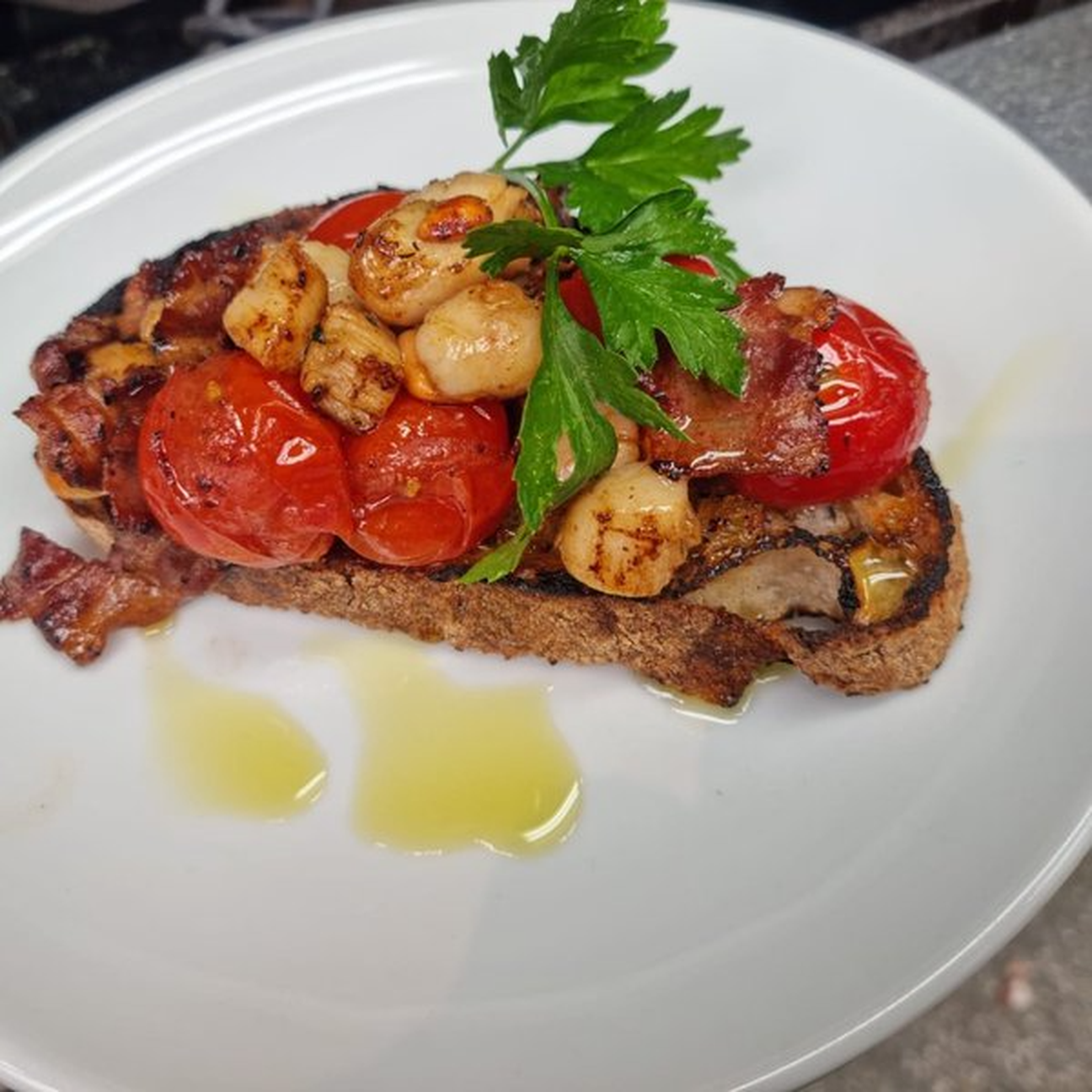 Bruschetta di capesante, pancetta e pomodorini confit.