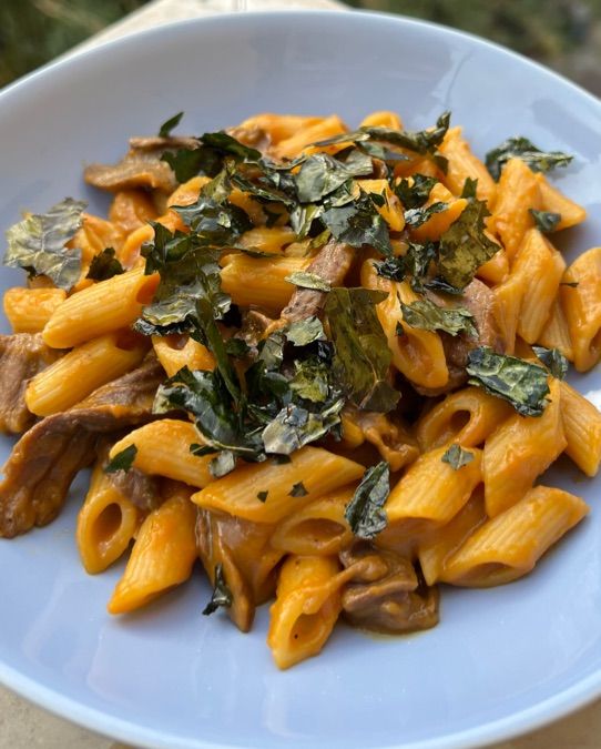 Penne cremose alla zucca, funghi e chips di cavolo nero