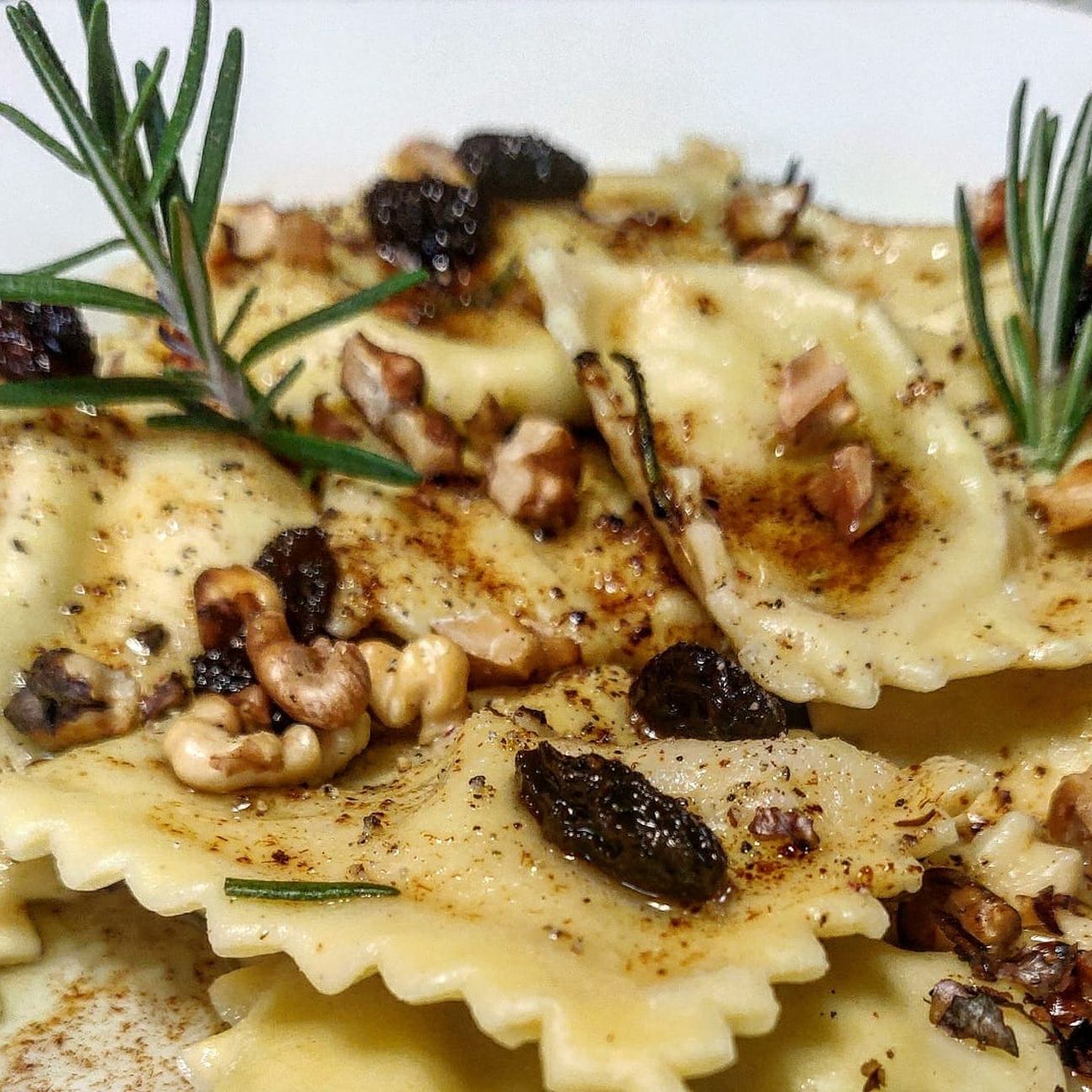 Ravioli di cavolfiore e ricotta con burro aromatizzato al rosmarino, uva sultanina e noci