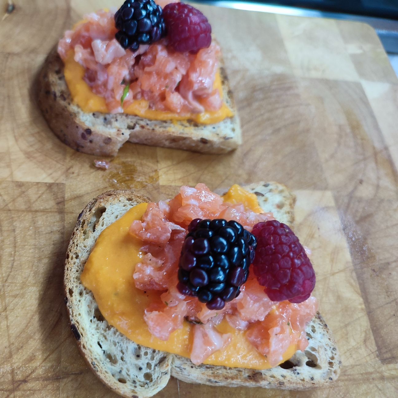 Pane tostato con vellutata di zucca,tartare di salmone e frutti di bosco