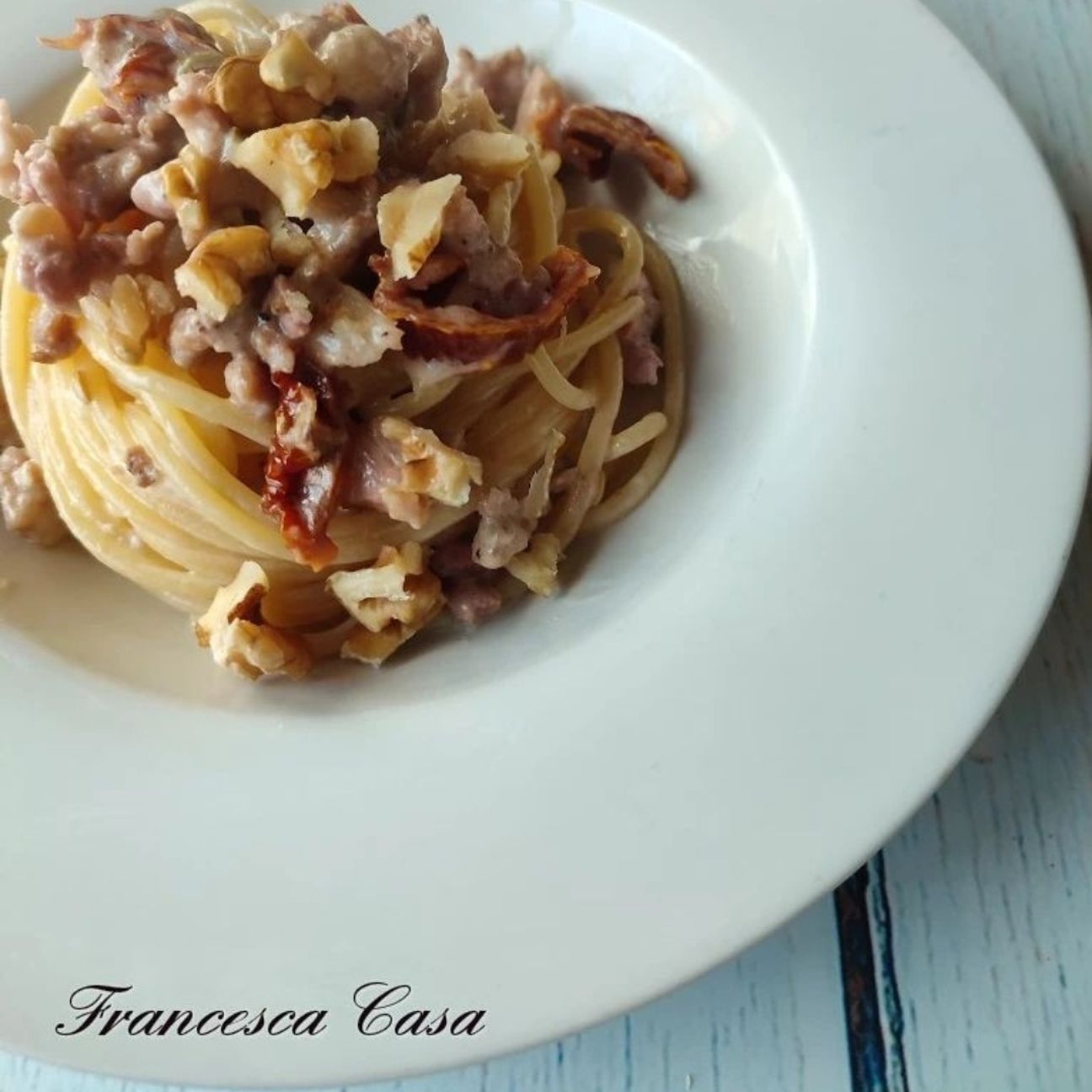 Spaghetti con salsiccia, pomodorini secchi, stracciatella di burrata e noci..