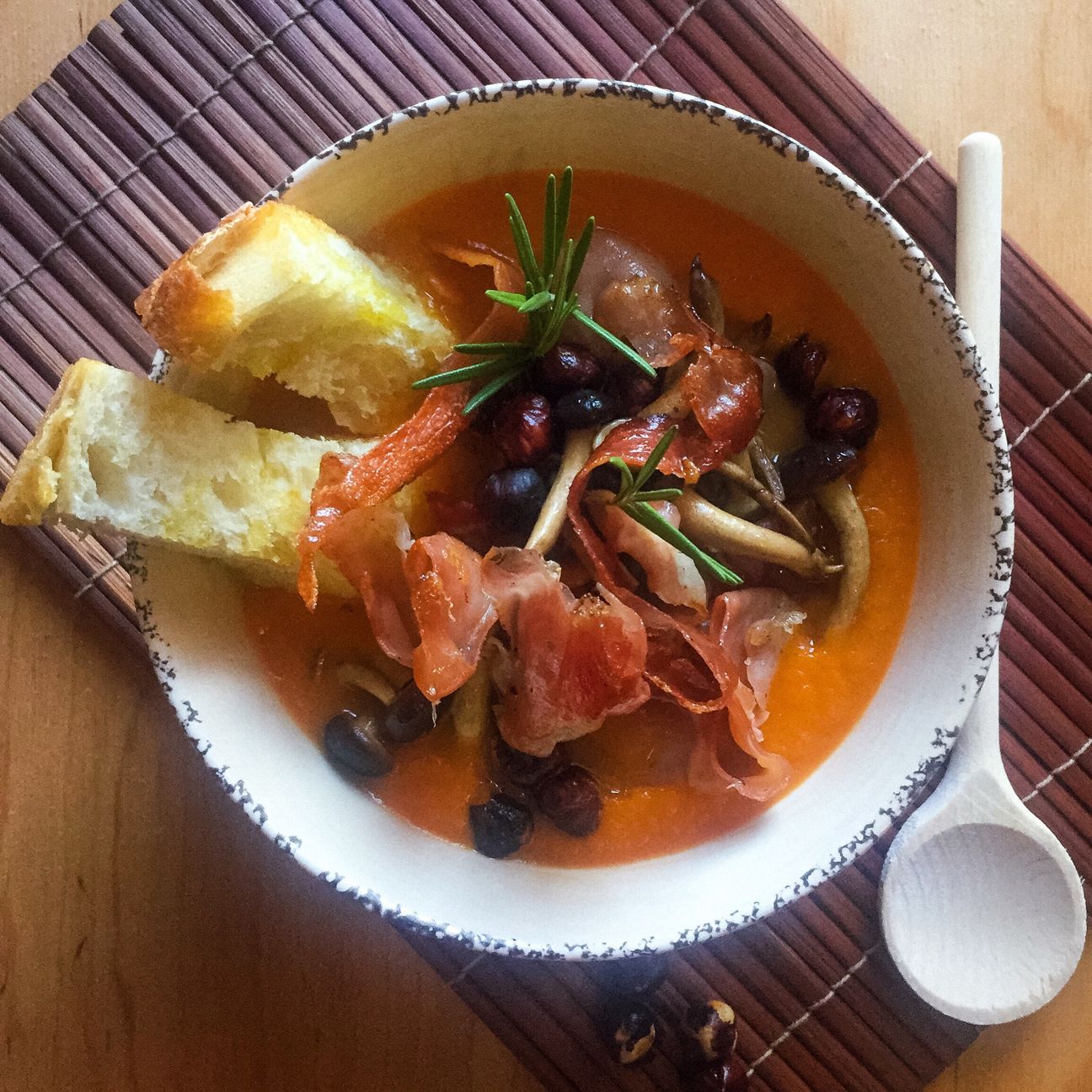Crema di zucca con funghi pioppini, speck croccante e nocciole tostate