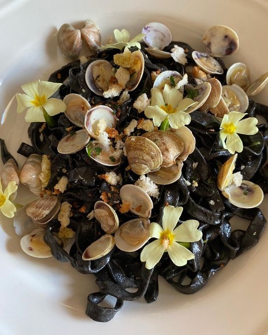 Tagliatelle al nero di seppia con vongole e pane croccante