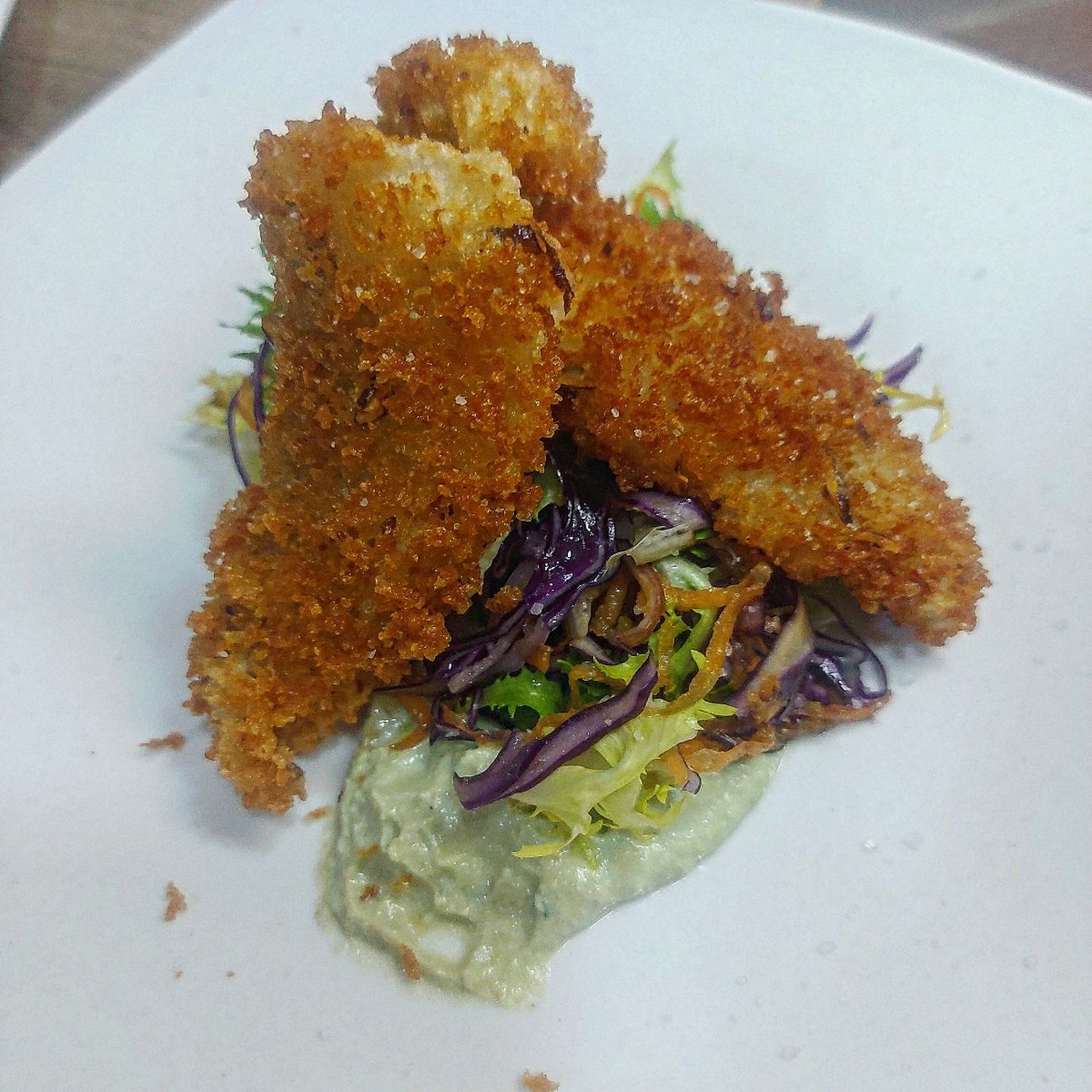 Filetti di Merluzzo Impanati su insalata di cavolo viola marinato e mousse di ricotta e fave.