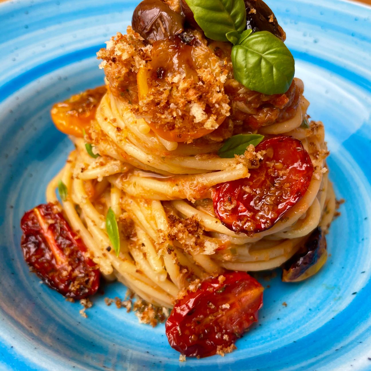 Spaghetti con crema di pomodorini rossi e gialli confit, tonno, olive taggiasche e crumble di pane croccante