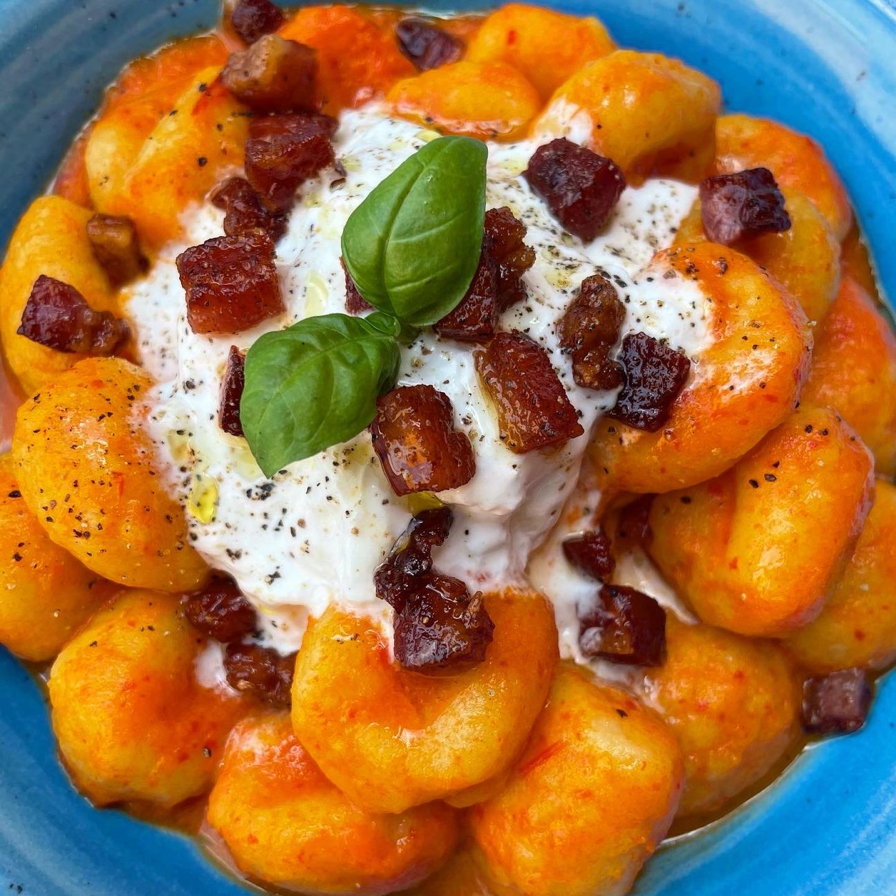 Gnocchi con crema di peperoni, stracciatella e pancetta croccante