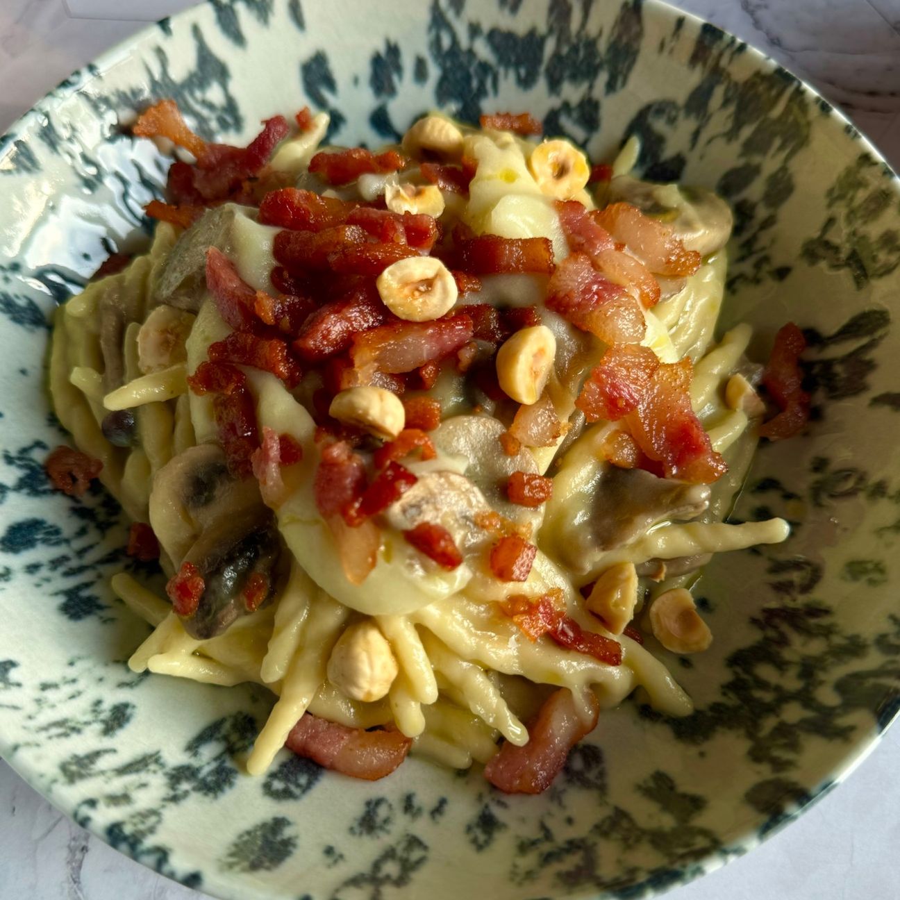Trofie con crema di patate, funghi misti, stick di guanciale croccante e nocciole