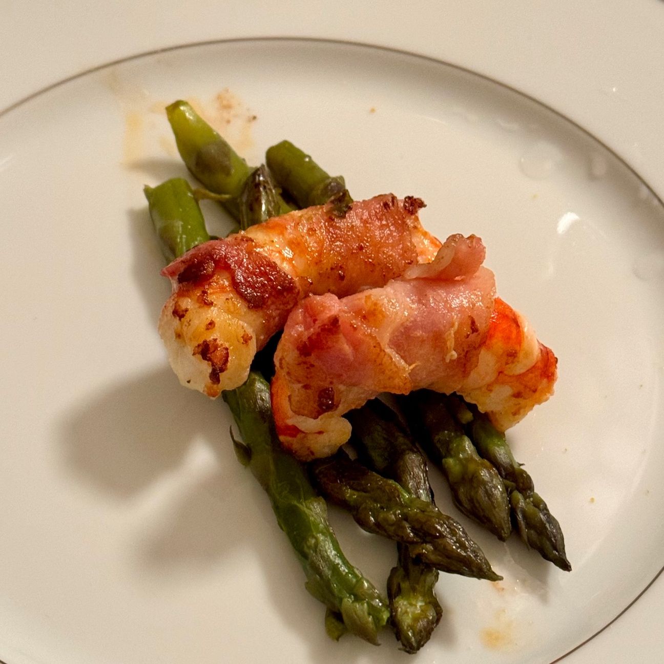 Gamberoni lardellati su letto di asparagi