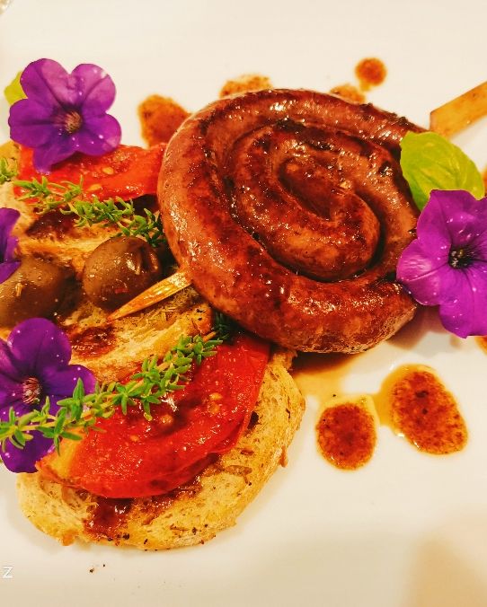 Salsiccia al Nero d'Avola, crostini di pane con crema d'aglio, basilico e menta caramellati