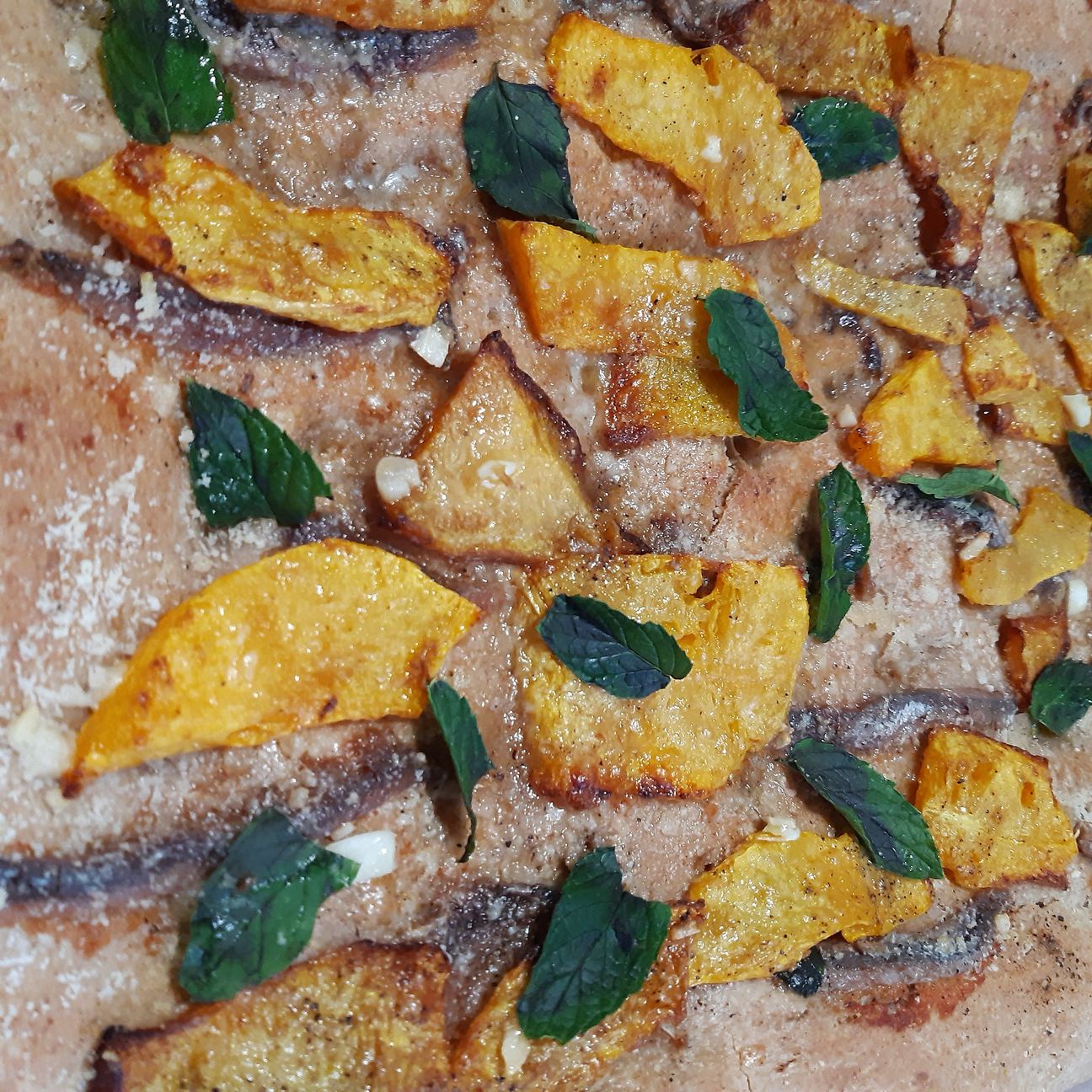 Focaccia di grano tumminia con sarde, zucca rossa, aglio, grana e profumo di menta