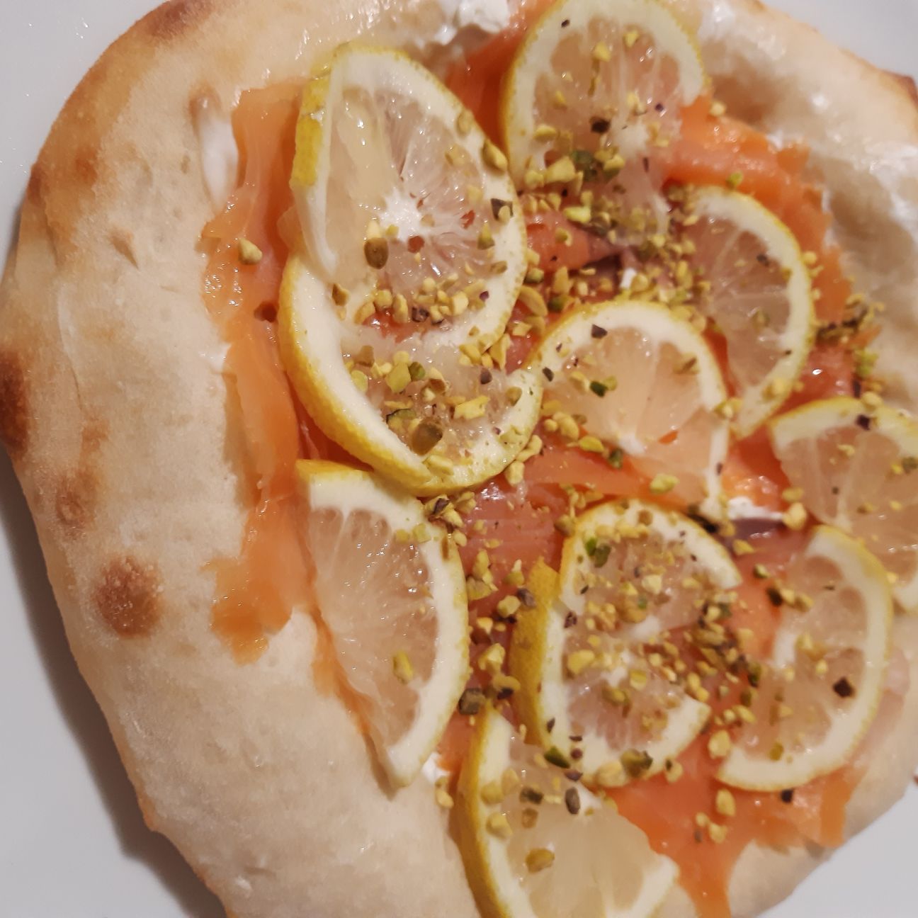 Pizza al salmone,stracchino, granella di pistacchi e fettine di limone