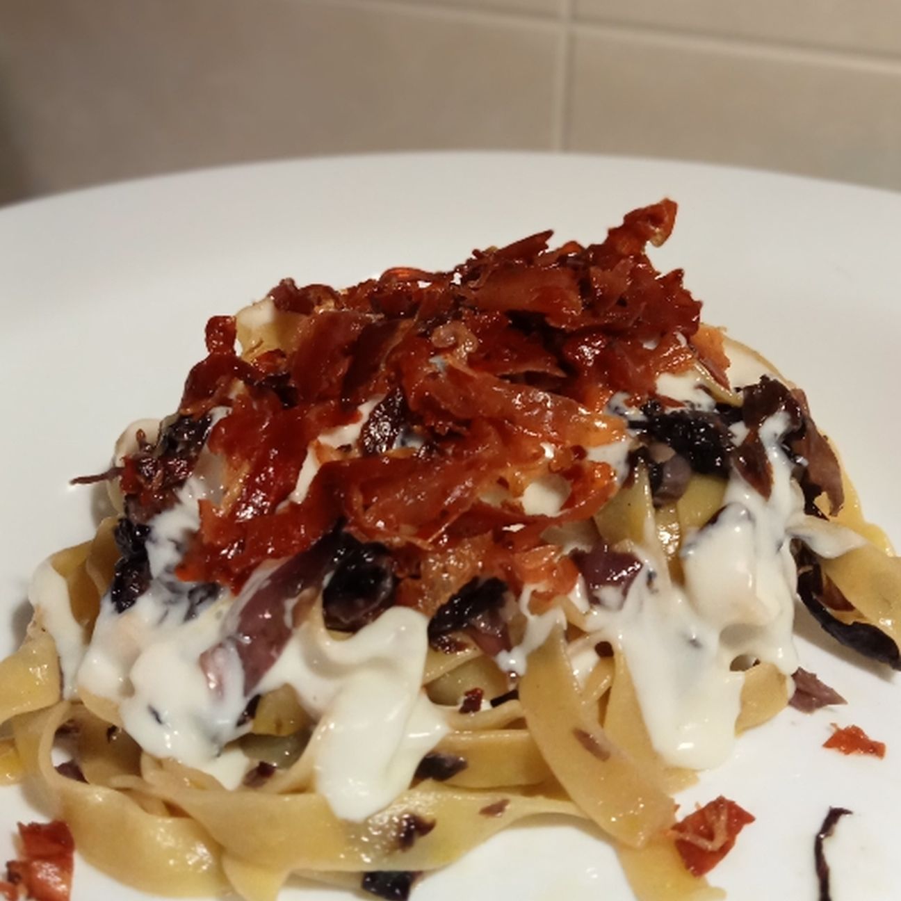 Tagliatelle speck croccante radicchio e fonduta di taleggio